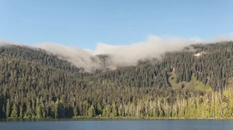 Time Lapse of Fog Rolling Over Mountains Next to a Small Lake Stock Footage 55809843