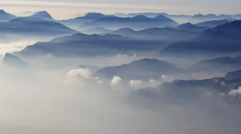 Time-lapse footage of clouds moving by a group of mountains Видео 63329200