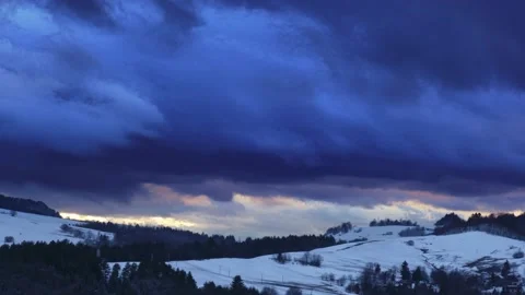 Time-lapse footage of dramatic clouds moving across a rural winter landscape at Stock Footage 235204411