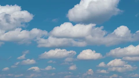 Time lapse footage of fast moving white puffy cumulus clouds on blue clear sky Stock Footage 164655328