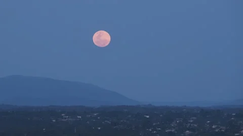 Time lapse of the Full Moon raising over a valley from behind a mountain Stock Footage 251878640