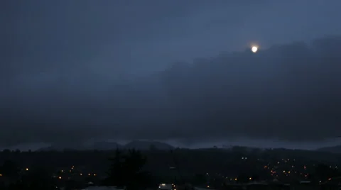 Time lapse of the full moon rising above the clouds and city during dusk Video stock 65242094