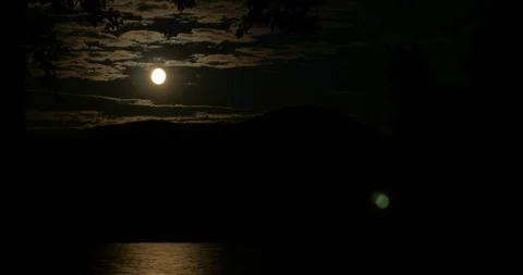 Time lapse of the full moon rising and reflecting in a lake and by the clouds Видео 90589465