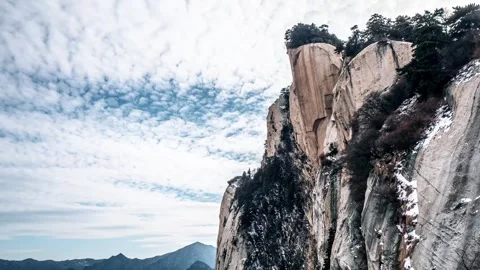 Time Lapse of Full Sky Fluffy Cloud Steep Peculiar Peak Rock Wall Thin Snow Stock Footage 337938241