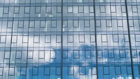 Time lapse of a glass skyscraper with clouds reflected in the office windows. Stock Footage 229021840