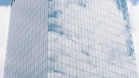 Time lapse of a glass skyscraper with clouds reflected in the office windows. Stock Footage 229023830