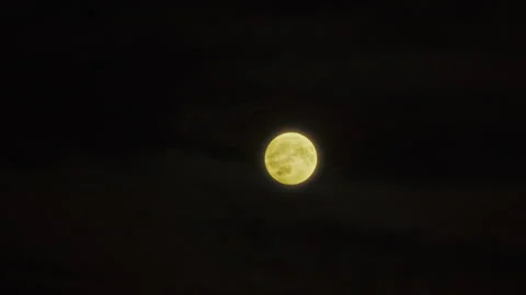 Time lapse, glowing full moon in the sky among clouds moving diagonally up Stock Footage 315403107