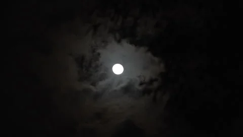 Time lapse of a glowing full moon behind fast-moving clouds Stock Footage 341483250