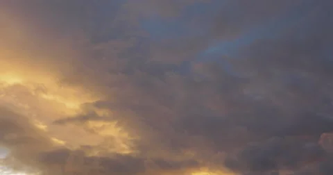 Time-lapse of golden clouds speeding by and fade to a blue sky. Stock Footage 47573477