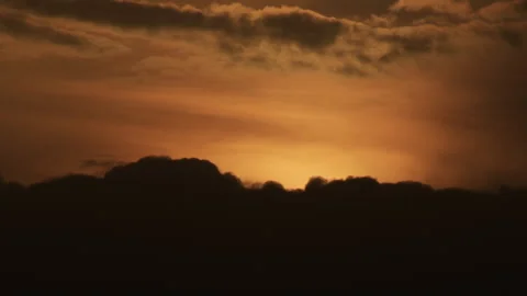 Time lapse of golden sunset with dark clouds moving over horizon Stock Footage 344988775