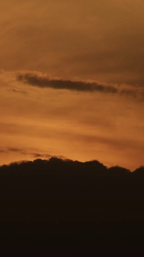 Time lapse of golden sunset with dark clouds moving over horizon. 4K Vertical 動画素材 344988857