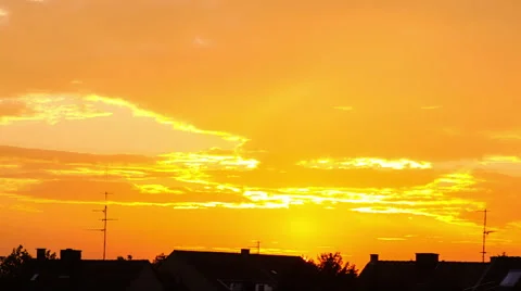 Time-lapse: Golden sunset over suburban town silhouette with dramatic cloudscape Stock Footage 56172901
