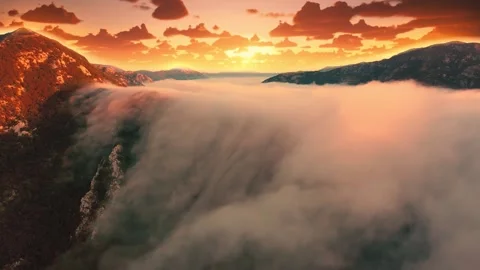 Time lapse of golden sunset over sharp rocky mountains covered with clouds Stock Footage 252979439