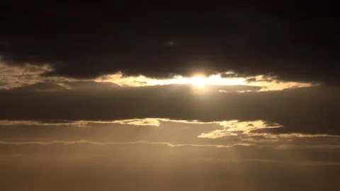 Time lapse Golden sunset as sun goes down in between clouds UK 4K 動画素材 115944899