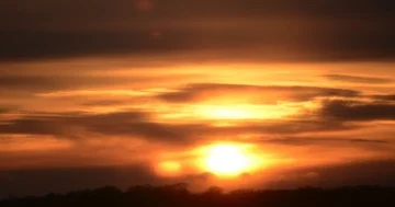 Time lapse: Gorgeous spring sunset behind clouds over mountain tree line 30fps Stock Footage 85966687