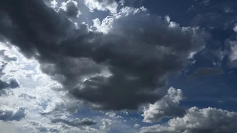 Time lapse of gray and white summer clouds moving through a blue sky with the Stock Footage 335898173