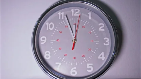 Time-Lapse of a Gray Clock With Red Minute Numerals on a White Background Stock Footage 337896708