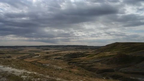Time lapse of gray clouds moving to the left above a dry prairie setting. Stock Footage 221572997