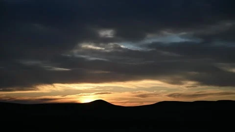 Time lapse of gray colored clouds in an orange colored evening sky at sunset Stock Footage 279657058