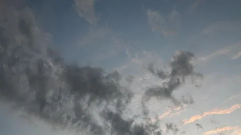 Time lapse of gray to light pink evening clouds drifting through a pale blue sky Stock Footage 314998966