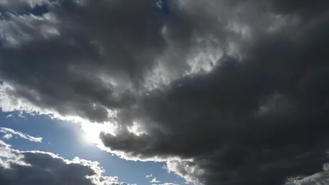 Time lapse of gray storm clouds moving in front of the sun creating sun-stars Stock Footage 289547851