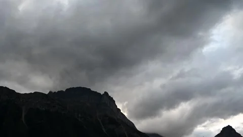 Time lapse of gray storm clouds churning above rugged rocky mountain peaks Stock Footage 300817748