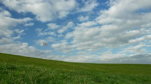 Time lapse of a green golf course with white flag. Clouds moving Vídeos de archivo 90556781