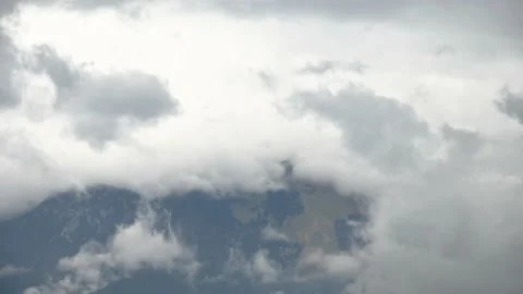 Time lapse of grey and white rainy clouds forming over the mountains Stock Footage 219690384