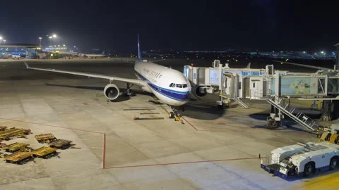 Time-lapse of ground crew work and airplane motion at night Stock Footage 320117581