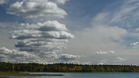 Time lapse of growing puffy white clouds in a blue sky above a lake.  Stock Footage 172158071