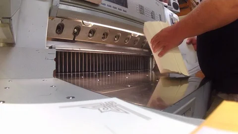 Time lapse of a guillotine operator sorting and cutting a large stack of Stock Footage 100632117
