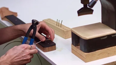 Time lapse of guitar maker inserting frets in guitar neck Stock-Footage 122030170