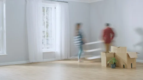 Time-Lapse: Happy Young Couple Moves into New Apartment, Arranges Furniture Stock Footage