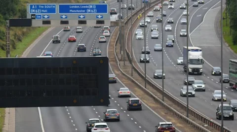 Time lapse of heavy traffic reflected in gantry sign on the motorway  Leeds, Uk Stock Footage 66296003