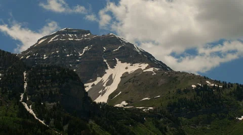 Time-lapse of a high mountain peak with snow patches and clouds. Stock Footage 52327491