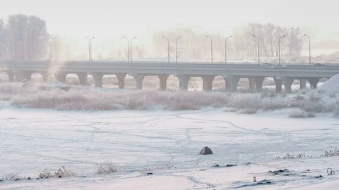 Time lapse of highway bridge acrossing frozen river in winter at frosty foggy Stock Footage 75302796