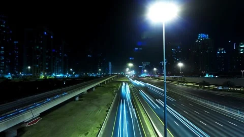 Time-Lapse of Highway Light Trails and City Skyline at Night Vidéo 332742244