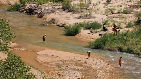 Time-lapse of hikers wading in river Stock Footage 128777599