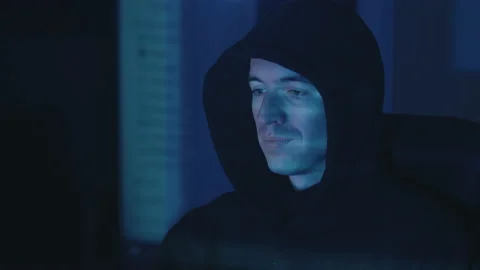Time-lapse of hooded dangerous hacker programmer working on computer scheming Stock Footage 146826752