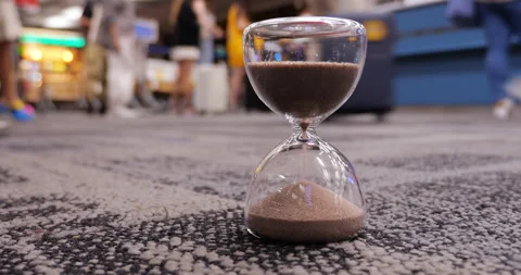 Time-lapse, hourglass counting time, boarding passengers blurred on background Vidéo 326390874