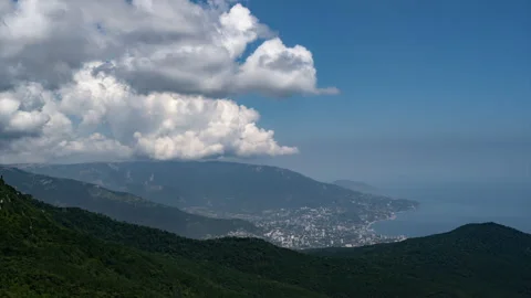 Time lapse. Huge clouds growing and moving over mountains, sea and city Stock-Footage 220294464