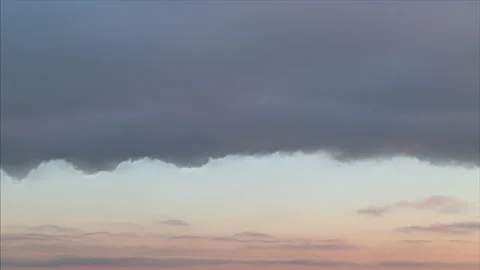 Time lapse. Huge grey rainy dark cloud moving on winter sunset orange sky Stock Footage 197842205