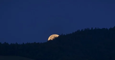 Time lapse of a huge moon rising up from behind the hill Stock Footage 113333595