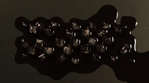 TIME-LAPSE: Ice cube melting on a black surface - Top View Stock Footage 100258154