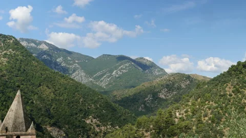 Time lapse with inzoom of clouds passing over mountains, seen from village in It Video stock 139862970