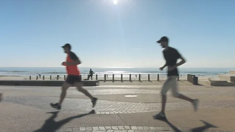 Time lapse of joggers with beach in background. Stock Footage 71679453