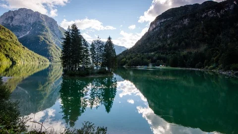 Time Lapse - Lago del Predil with trees on an island and moving clouds Stock Footage 99364470