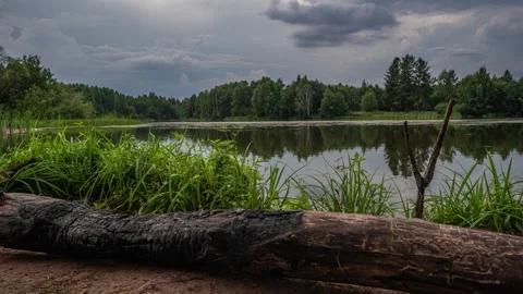 A time lapse of a lake reflecting the moving clouds above, video loop, beautiful Stock Footage 255346504