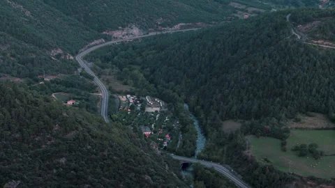 Time-lapse landscape of a valley as dusk falls, with the trail of car headlights Video stock 310784865