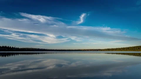 Time lapse of a large calm lake surrounded by autumn colored trees and clouds  Stock Footage 163293038